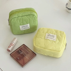 Quilted floral cosmetic bags in candy colors with top zipper and woven label detail