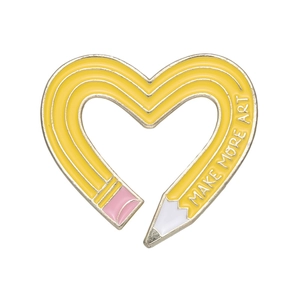 Cute yellow pencil heart enamel pin featuring Make More Art text with gold trim