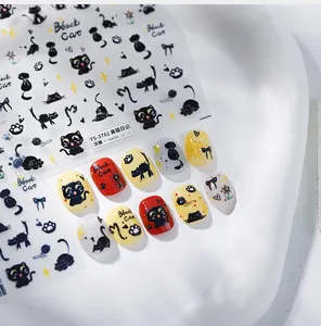 Detail of 3D embossed black cat nail stickers with metallic gold accents on white base