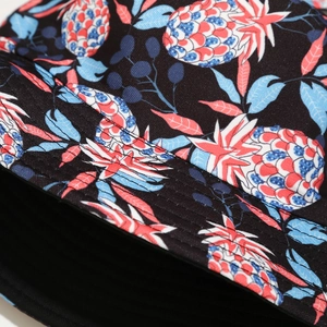 Close-up of colorful pineapple pattern on reversible black canvas sun bucket hat