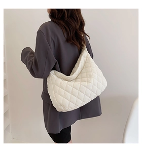 Macro shot of white quilted puffy shoulder bag texture with soft cloud pleats