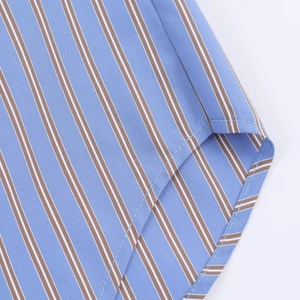 Detalle del dobladillo curvo en camisa de rayas con costuras finas y textura de tela