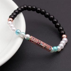 Detail of beaded bracelet with rose gold tube charm and pavé rainbow cubic zirconia
