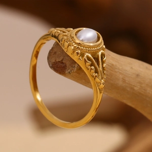 Macro view of gold flower pearl ring with vintage hollow pattern on wood branch
