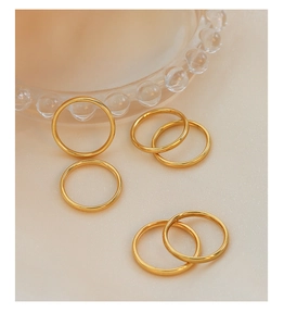 Detailed view of minimalist rose gold titanium rings set against soft fabric background