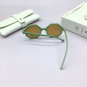 Detail of light green octagonal kids sunglasses with UV400 lenses and white leather pouch