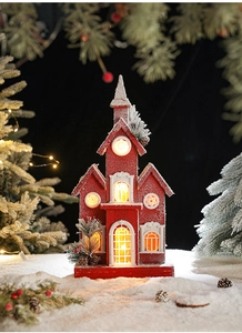 Detail of red glowing wooden church ornament with snow dust and berry accents