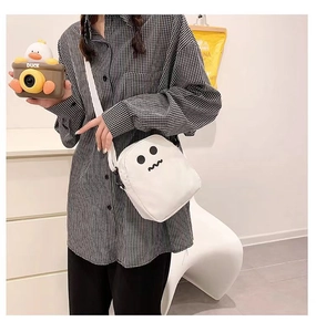 Détail du sac bandoulière blanc avec motif monstre et sangle ajustable