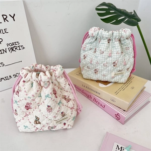 Close-up of quilted drawstring storage bags with cute cartoon rabbit and bear patterns