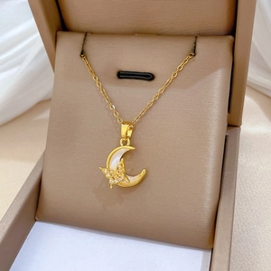 Close-up of golden moon and shell butterfly pendant necklace in a velvet jewelry box