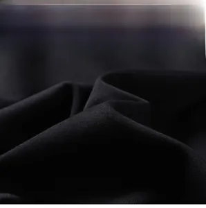 Gros plan sur la texture du tissu noir montrant le tissage fin et le drapé du sweat-shirt