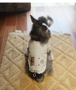 Detail view of cream pet vest featuring red plaid pocket and adjustable hem drawstring