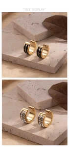 Detail of gold titanium steel hoop earrings with double row diamonds on stone