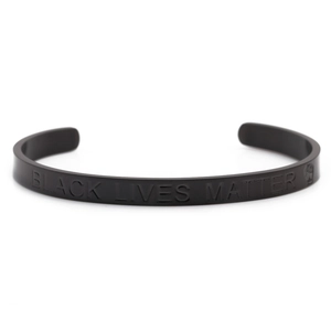 Macro detail of matte black stainless steel cuff bracelet with Black Lives Matter engraving