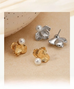 Detailed macro view of gold and silver flower petal earrings with center pearls