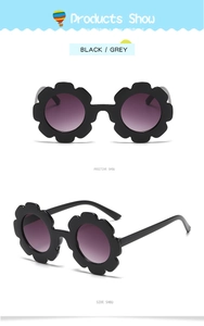 Close-up of flower shaped children's sunglasses in black frame with grey gradient lenses