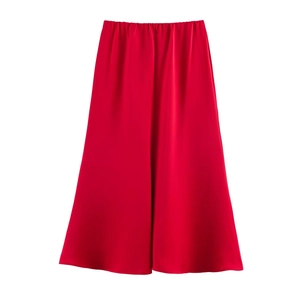 Détail de la jupe en satin rouge montrant la texture soie et le drapé fluide