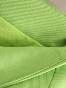 Macro detail of grass green woven fabric showing precise stitching and fine texture