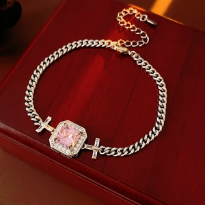 Close-up of pink square zircon bracelet with silver Cuban chain on wood jewelry box