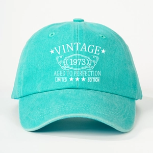 Close-up of VINTAGE 1973 white printed text on mint green washed cotton baseball cap