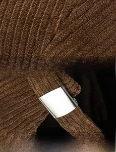Macro shot of brown corduroy texture and adjustable metal buckle on the retro docker hat