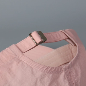 Detail of pink quick-dry baseball cap featuring a silver metal buckle for adjustable fit