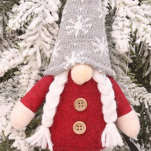 Christmas gnome doll with grey knit snowflake hat and red felt body hanging on tree