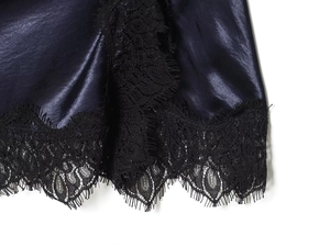 Gros plan sur l'ourlet en satin bleu foncé avec détails en dentelle de cils noire