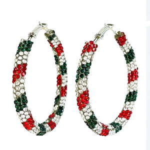 Gros plan de boucles d'oreilles de Noël avec strass rouges verts et blancs sur argent