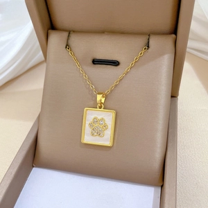 Macro view of gold-plated square shell necklace with diamond-encrusted cat paw motif