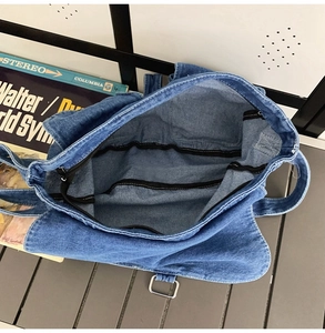 Vue intérieure du sac bandoulière en denim avec compartiment zippé et poche interne