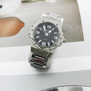 Detail view of octagon bezel men's watch with steel strap and luminous numbers on dial