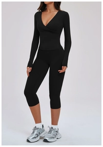 Detail of female sports set featuring V-neck wrap top and high waisted black yoga leggings
