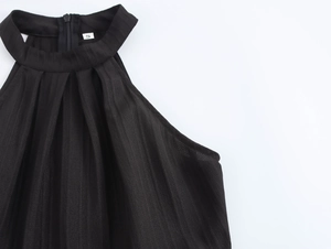 Detail view of the halter neckline and pleated fabric texture on this black maxi dress
