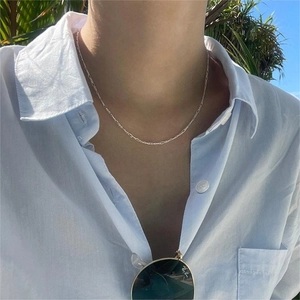 Minimalist 925 sterling silver fine chain necklace worn with a light blue shirt