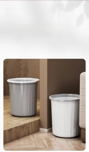 Close-up of modern gray and white trash cans featuring vertical striped texture and ring lid