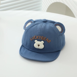 Détail d'une casquette bleue pour bébé avec broderie LUCKYBEAR et oreilles d'ours 3D