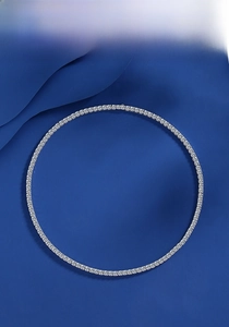 Detailed top view of a S925 sterling silver classic four-prong tennis necklace on blue