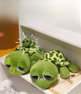Primo piano di simpatici peluche a forma di tartaruga verde in due misure con occhioni