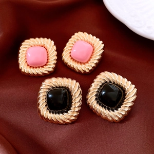 Vintage square textured earrings in pink and black on dark brown satin fabric backdrop
