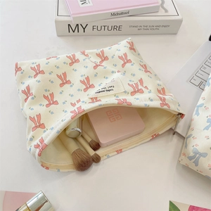 Neceser de lona con lazos sobre un escritorio con accesorios de belleza diarios