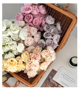 Close-up of artificial peony silk bouquet in various colors within a woven basket