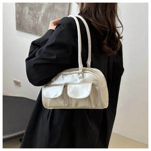 Detail of silver pearl-gloss shoulder bag with double pockets on black blazer
