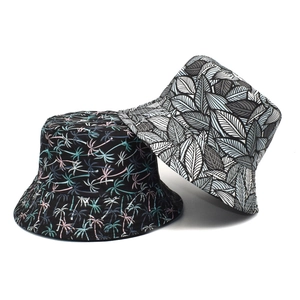 Double-sided reversible bucket hat featuring tropical palm and leaf print patterns