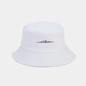 Detailed view of white cotton bucket hat featuring black 'whatever' script embroidery
