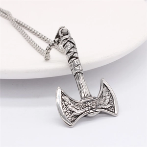 Nordic Viking double eagle axe pendant necklace in polished stainless steel on white tray