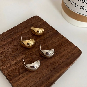Minimalist C-shape water drop stud earrings in gold and silver mirror finish on wood