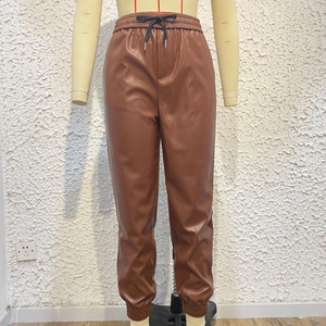 Dettaglio dei jogger in pelle PU marrone con coulisse nera e girovita elasticizzato