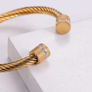 Gold twisted wire stainless steel bangle with white rhinestone detailing on open ends