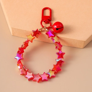 Close-up of a red star beaded keychain with matching bell and metallic clasp detail